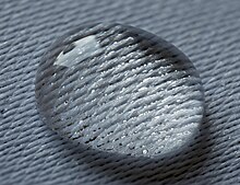 Water droplet lying on a damask. Surface tension is high enough to prevent seeping through the textile Water droplet lying on a damask.jpg