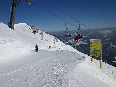 Skipiste mit Sessellift an einem sonnigen Tag