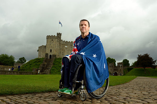 Greg Smith wraps himself in the Australian Flag outside Cardiff Castle after the announcement that he would be the 2012 Australian Flag Bearer