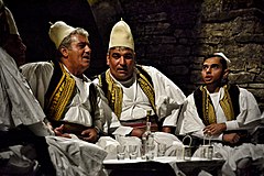 Iso-polyphony ensemble Grupi Argjiro wearing tall qeleshes with a small protrusion on the top, Gjirokastër