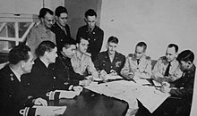 An Allied Translator and Interpreter Section "scanning conference". An American Nisei scans a captured document while Mashbir and representatives of several arms and services (including a Chinese General) look on and listen. ATIS scanning conference.jpg