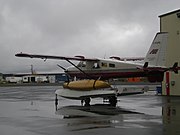 An Arctic Sunwest de Havilland Beaver on floats with a canoe lashed to the side.