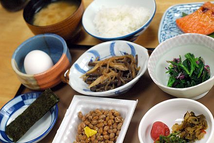 Japanese breakfast at a ryokan. Clockwise from top left: miso soup, rice, cold grilled fish, vegetables, pickles, nattō fermented soybeans, nori seaweed, a raw egg (stir it into your rice), and more vegetables.