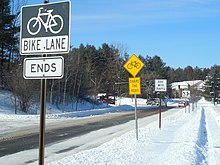 Signed "Conventional bike lane" with snow-covered road surface markings. BicycleLaneSignage SBTV 20150205.jpg