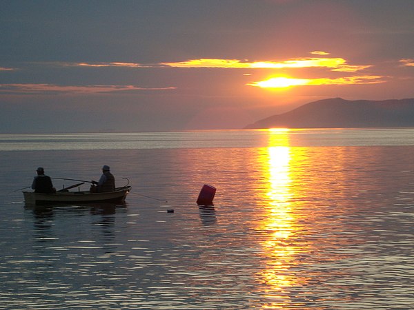 Two fishermen on a boat in the gulf.