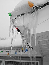 A string of electric Christmas lights, unlit, decorating the edge of a roof on a house in Keswick, Ontario, Canada; Christmas 2008 Christmaslightsnowyicyroof.jpg