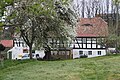 Wohnstallhaus mit angebautem Backhaus, Scheune, Seitengebäude und Einfriedungsmauer eines Bauernhofes