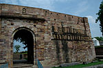 The (fine) doorway built into the ruined wall beside the north gateway to the fort and the carved stones and images lying about within the boundaries of the village