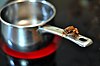 A frog sitting on a saucepan handle