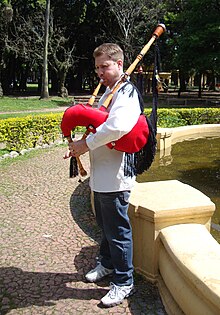 A gaiteiro playing a gaita (bagpipe) Galician gaita.JPG