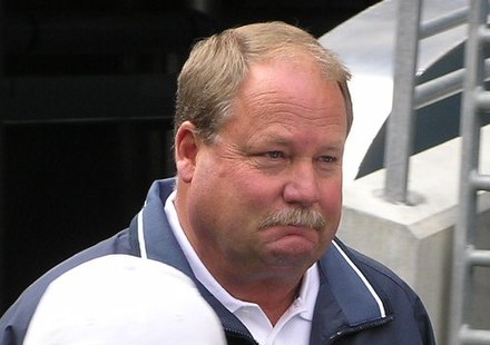 Candid head and shoulders photograph of Holmgren wearing a green jacket over a white shirt