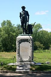 "The Minute Man" by Daniel Chester French at the North Bridge was meant to represent the typical provincial but was also inspired in large part by the story of Capt. Isaac Davis of Acton who died where the statue now stands. It is inscribed with verse from Emerson's "Concord Hymn". Minuteman statue 3 - Old North Bridge.jpg