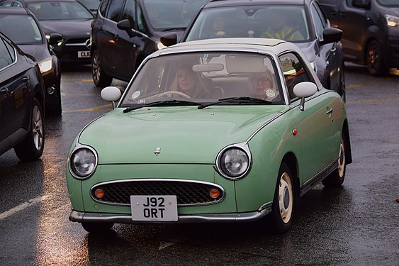 A green car in a sea of grays