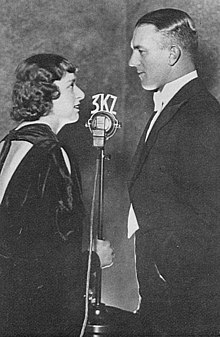 Naomi ("Joan") Melwit and Norman Banks at the 3KZ microphone, in the late 1930s. Banks was one of Melbourne's (and Australia's) most prominent broadcasters at 3KZ (1930-1952) and 3AW (1952-1978). He is remembered for founding Carols by Candlelight, as a pioneer football commentator, and for hosting both musical and interview programs. In later years he was one of Melbourne's first and most prominent talkback hosts. At the commencement of his career, Banks was known for his double entendres and risque remarks; as a talk back host he was outspoken in his conservative views, especially regarding the White Australia policy and Apartheid. In 1978 his 47-year career in radio was hailed as the longest in world history. Norman Banks Naomi Melwit 3KZ.jpg
