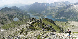 Descente du GR10 vers le sud depuis le col de Madamète. Au premier plan, les lacs Gourg de Rabas à gauche, d'Aumar au centre, et d'Aubert à droite. En second plan à droite, l'arête du pic de Néouvielle. En arrière-plan, de droite à gauche, le pic de Campbieil, le pic d'Estaragne, le pic Méchant et le pic de Bugatet. Tout au fond à gauche dans la brume, de droite à gauche, le pic d'Aret en vallée d'Aure et le massif de Batchimale.