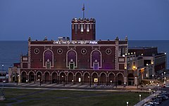 Paramount Theatre at Asbury Park Convention Hall at nightfall with the Atlantic Ocean behind it.