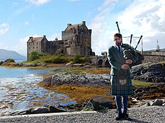 English: Piper in front of Eilean Donan Castle