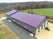 Post frame Barndominium with standing seam metal roof. Large garage on the front side and living space on the back end. Post frame building.jpg