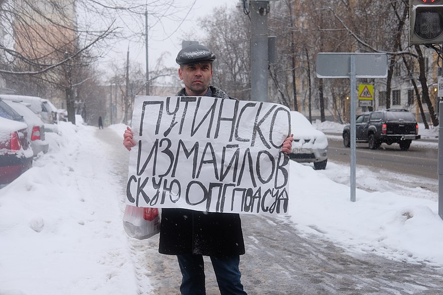 15:15 — Одиночный пикетчик держит транспарант. Надпись: «Путиноизмайловскую ОПГ под суд».