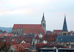 Gotik: Die spätgotische Stiftskirche wurde 1470-83 anstelle zweier Vorgängerkirchen unter Graf Eberhard im Bart errichtet. Im Bild die Stiftskirche von Norden, rechts im Vordergrund die neugotische Johanneskirche (1879)