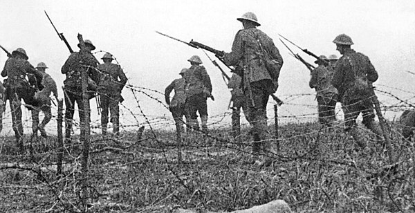 Staged scene of British troops advancing through barbed wire from The Battle of the Somme, 1916