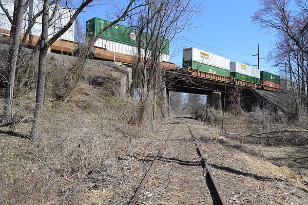 A Norfolk Southern intermodal freight train on the Trenton Cutoff passes over SEPTA's dormant Fox Chase/Newtown Line in 2015