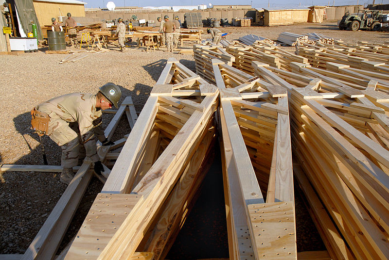 File:US Navy 080202-N-0553R-001 Construction Electrician Constructionman Recruit Daniel Kingsley, assigned to Naval Mobile Construction Battalion (NMCB) 1, stacks prefabricated trusses to be used in the construction of Southwest Asi.jpg