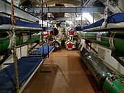S型潜水艦（S-56）の発射管室。壁面には兵員用の簡易ベッド、天井には魚雷搬送用のホイストクレーンが設けられている。