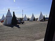 アリゾナ州ホルブルックのウィグワム・モーテル。インディアンのテント風のコテージに、宿泊客の車が横付けされている