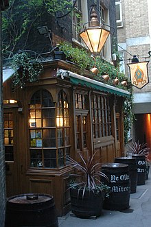 Photograph of the exterior of a pub surrounded by barrels