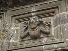 The carving depicting a man holding a skull and a human bone