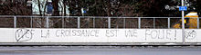 Anti-WEF graffiti in Lausanne. The writing reads: La croissance est une folie ("Growth is madness"). Anti WEF graffiti Lausanne.jpg