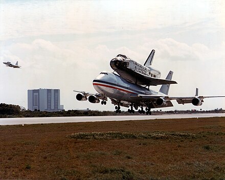 Deke Slayton flying T-38 (far left) during the return of 
B 747 SCA airplane with Space Shuttle Columbia on board just before touchdown at Kennedy Space Center, March 1979