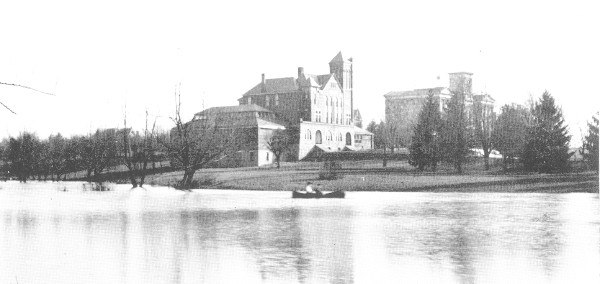 The early campus: Barker Hall in the center, the Main Building to the right, and a lake in the foreground where the Student Center was later built.