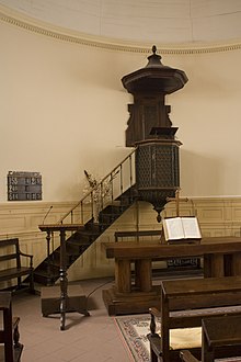 Vue d’une chaire à prêcher en bois dans un édifice religieux.