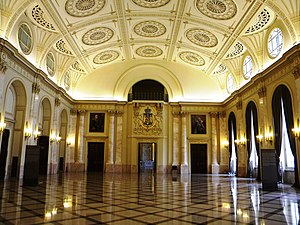 The Throne Hall, restored after 1989. The Royal Coat of Arms of Romania, middle version, is visible at center, with pictures of King Carol I (left) and King Ferdinand I (right) around it Bucuresti, Romania, Palatul Regal (Muzeul National de Arta al Romaniei - Pavilionul Sala Tronului - Sala Tronului interior 1 ); B-II-m-A-19856.JPG