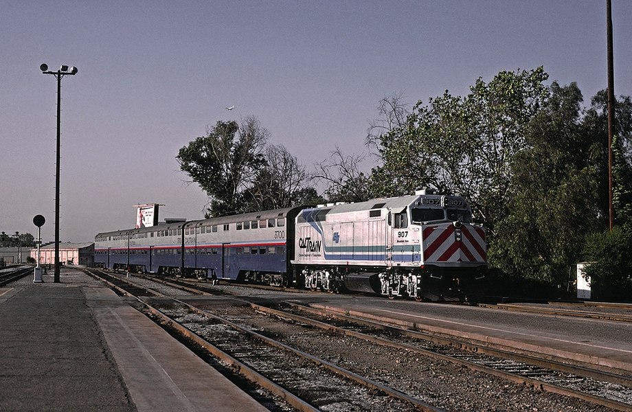907 "Mountain View" with Caltrans blue-and-teal stripes with the three "Rainbow" gallery cars CDTX 3700, 3701, 3702 (1985)