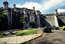 Cuba, Havana. Fortress wall and Cuban flag at San Carlos de