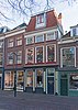 Winkelwoonhuis met voorgevel uit de 18de eeuw, gemoderniseerd in de 19de eeuw, in opzet mogelijk ouder. Traditioneel-classicistische vormen.