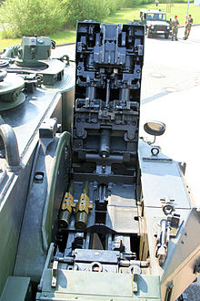 foto van een kanon van bovenaf gezien, met open deksel en twee granaten klaar om te worden ingeschakeld