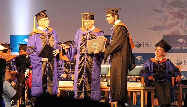 Student receiving academic degree from Azim Premji during convocation. Adi Godrej in background.