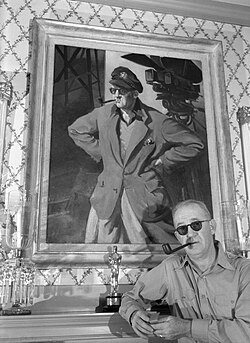 ג'ון פורד עומד לפני דיוקן של עצמו ולצידו פסלון פרס האוסקר, 1946