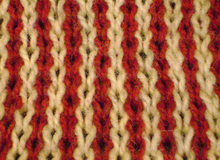 Alternating wales of red and yellow knit stitches. Each stitch in a wale is suspended from the one above it. Knitting wales slip stitch.png