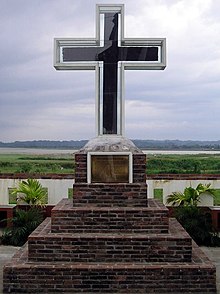 The evangelization cross of Lal-lo from Spanish colonial period, in front of the Nueva Segovia Church. The Cagayan River can be seen in the background. Lal-lo Evangelization Cross - Flickr.jpg