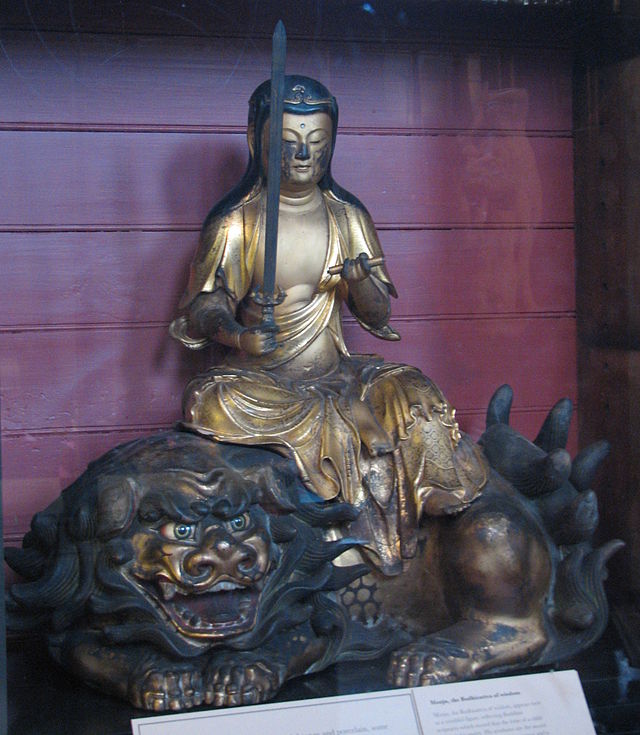 photo d'une statue japonaise en bronze du bodhisattva de Manjusri, portant une épée et assis sur un lion menaçant