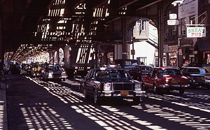 Traffic on Roosevelt Avenue in Jackson Heights, New York City, under the elevated IRT Flushing Line (used by the 7 and <7> trains
) in the 1980s Roosevelt-avenue-queens-nyc cars driving-under-elevated-railway-line 1980s.jpg