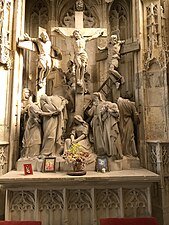 Grand groupe sculpté représentant trois hommes sur des croix. A leurs pieds, 7 personnages pleurant.