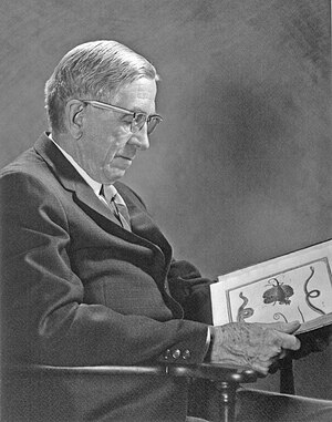 S. Stillman Berry, seated holding a rare book from his collection, c. 1960s