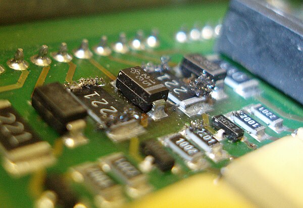 Silver sulfide whiskers growing out of surface-mount resistors.