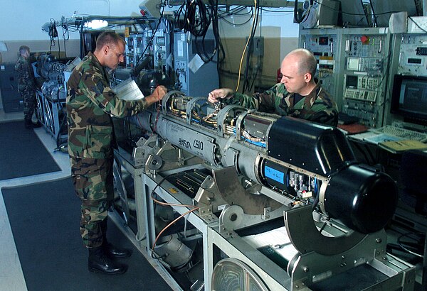 Inspecting an AN/ALQ-184 Electronic Attack Pod.